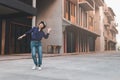 Happy young asian woman listening to music and having fun with headphones via smartphone on the street. Royalty Free Stock Photo