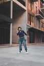 Happy young asian woman listening to music and having fun with headphones via smartphone on the street. Royalty Free Stock Photo