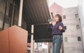 Happy young asian woman listening to music and having fun with headphones via smartphone on the street. Royalty Free Stock Photo