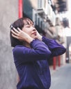 Happy young asian woman listening to music with headphones on the street. Royalty Free Stock Photo