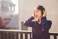 Happy young asian woman listening to music with headphones on the street. Royalty Free Stock Photo