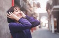 Happy young asian woman listening to music with headphones on the street. Royalty Free Stock Photo