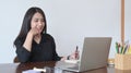 Young asian woman looking at laptop computer screen and making notes on notebook. Royalty Free Stock Photo