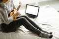 Happy young asian woman playing ukulele sitting on bed in bedroom. Royalty Free Stock Photo