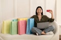 Happy young asian woman shopaholic shopping from home, using laptop Royalty Free Stock Photo