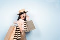Happy young asian woman shopping trendy clothes on blue background