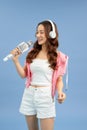 Happy young Asian woman singing with microphone sing and headphone over blue background Royalty Free Stock Photo