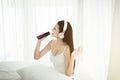 Happy young asian woman singing and using headphone listening to music with dance in bedroom,Relaxing time Royalty Free Stock Photo