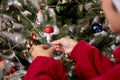 Happy young asian woman smiling hanging decorating ornament on Christmas tree in the living room at home.