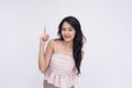 A happy young asian woman smiling in a sleeveless pink blouse giving some tips or reminders. Isolated on a white background Royalty Free Stock Photo