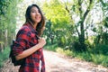 Happy young Asian woman traveler with backpack walking in forest. Hiker Asian woman with backpack walking on path in summer forest Royalty Free Stock Photo