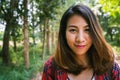 Happy young Asian woman traveler with backpack walking in forest. Hiker Asian woman with backpack walking on path in summer forest Royalty Free Stock Photo