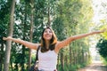 Happy young Asian woman traveler with backpack walking in forest. Hiker Asian woman with backpack walking on path in summer forest Royalty Free Stock Photo