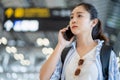 Happy young asian woman traveling waiting at flight gates for plane boarding. She Useing Mobile Smartphone Royalty Free Stock Photo