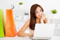 Happy young asian woman using a laptop with bags. Royalty Free Stock Photo