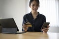 Young asian woman using smart phone and holding credit card for online banking or online shopping. Royalty Free Stock Photo