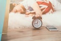 Happy young asian woman waking up and turning off the alarm clock Royalty Free Stock Photo