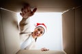 Happy young asian woman wearing christmas hat and unpacking gift box Royalty Free Stock Photo