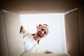 Happy young asian woman wearing christmas hat and unpacking gift box Royalty Free Stock Photo