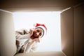 Happy young asian woman wearing christmas hat and unpacking gift box Royalty Free Stock Photo