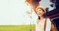 Happy young Asian woman wearing a hat and smiling with sitting on a back car, travel in the summer on a clear day on green meadow. Royalty Free Stock Photo