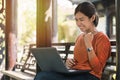 Happy young asian woman working with her laptop and enjoying his online winner success  in the park outdoors on vacation time Royalty Free Stock Photo