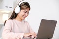 Happy young asian woman with working with laptop computer headphones at home Royalty Free Stock Photo