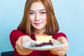 Happy young attractive Asian woman smiling and handing a piece o