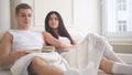 Happy young attractive couple sitting together on the couch talking, laughing and reading a book Royalty Free Stock Photo