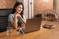 Happy young attractive woman working or learning online through her laptop computer at home in her living room Royalty Free Stock Photo