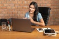 Happy young attractive woman working or learning online through her laptop computer at home in her living room Royalty Free Stock Photo