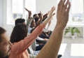 Happy young audience raising their hands to ask questions of speaker after lecture Royalty Free Stock Photo