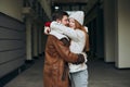 Happy young awesome couple in coats hugging on city street Royalty Free Stock Photo