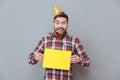 Happy young bearded birthday man holding copyspace board