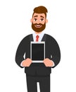 Happy young bearded business man showing/holding blank screen of new digital tablet computer in hands. Modern technology, latest.