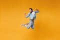 Happy young bearded man in casual blue shirt posing isolated on yellow orange background, studio portrait. People Royalty Free Stock Photo