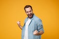 Happy young bearded man in casual blue shirt posing isolated on yellow orange wall background, studio portrait. People Royalty Free Stock Photo