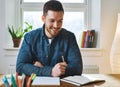 Happy young bearded man looking at notebook