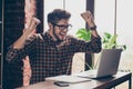 Happy young bearded manager with laptop completing task and triumphing Royalty Free Stock Photo