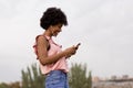 Happy young beautiful afro american woman listening to music on her mobile phone and smiling. urban background. Spring or summer Royalty Free Stock Photo
