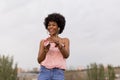 Happy young beautiful afro american woman listening to music on her mobile phone and smiling. urban background. Spring or summer Royalty Free Stock Photo