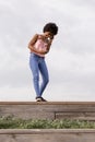 Happy young beautiful afro american woman smiling and talking on her mobile phone. cloudy background. Spring or summer season. Royalty Free Stock Photo