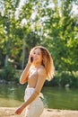 Happy young beautiful afro american woman smiling and using mobile phone. Green background. Spring or summer season Royalty Free Stock Photo