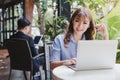 Happy young beautiful asian woman using laptop computer at outdoor coffee shop. Businessman background Royalty Free Stock Photo