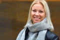 Happy young beautiful blonde woman smiling against rusty old metal wall Royalty Free Stock Photo