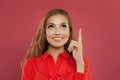 Happy young beautiful cheerful woman pointing up on colorful pink background portrait. Student girl pointing finger and looking up Royalty Free Stock Photo