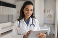 Happy young beautiful doctor woman using tablet for online communication Royalty Free Stock Photo