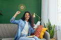 Happy young beautiful Hispanic woman sitting on sofa at home. Received a letter with good news Royalty Free Stock Photo