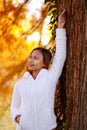 Happy young beautiful woman in autumn park on sunny day, Young woman in white coat during sunset in the park Royalty Free Stock Photo