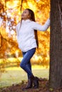 Happy young beautiful woman in autumn park on sunny day, Young woman in white coat during sunset in the park Royalty Free Stock Photo